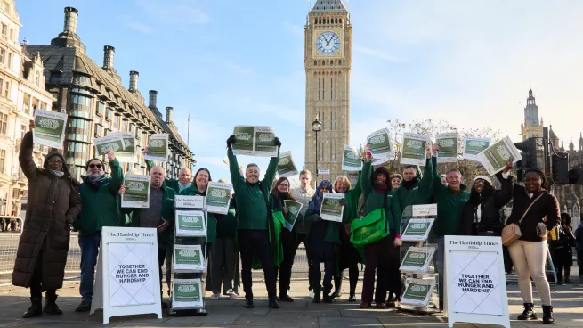 Group of people promoting The Hardship Times with Elizabeth Tower in the background