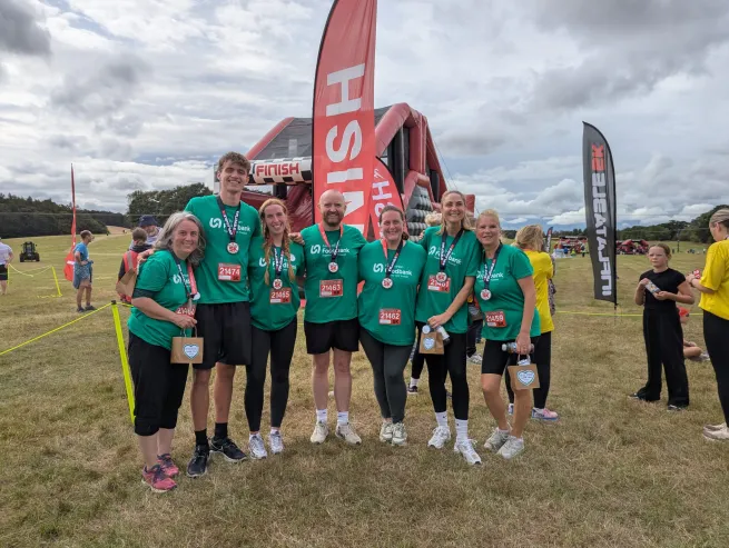 A team of seven people standing together at a sports fundraising event