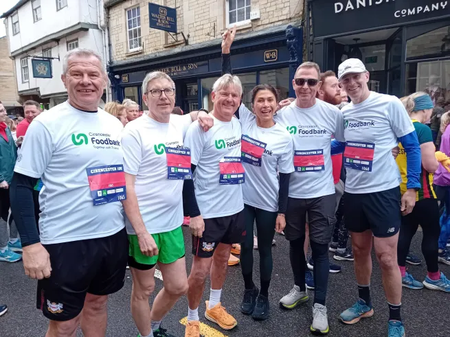 A group of five people, with Cirencester Foodbank running tops on. They are standing in a line, after completing the Cirencester 10k