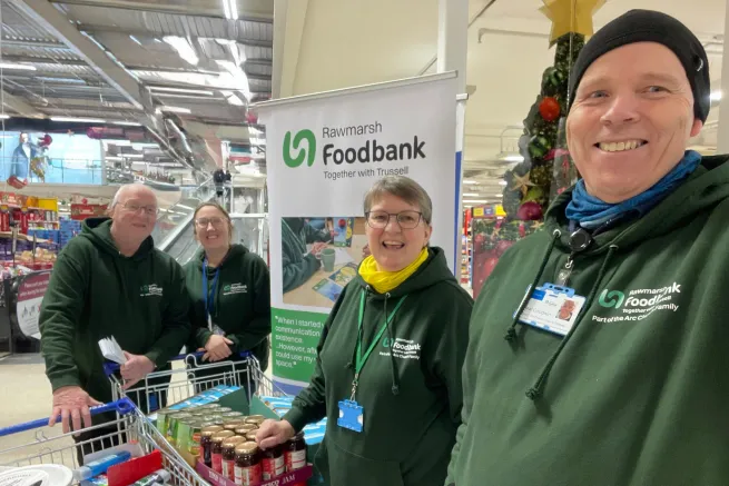 Four volunteers in supermarket with trolleys of donated food