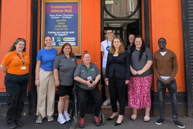Nine campaigners stand outside community advice hub