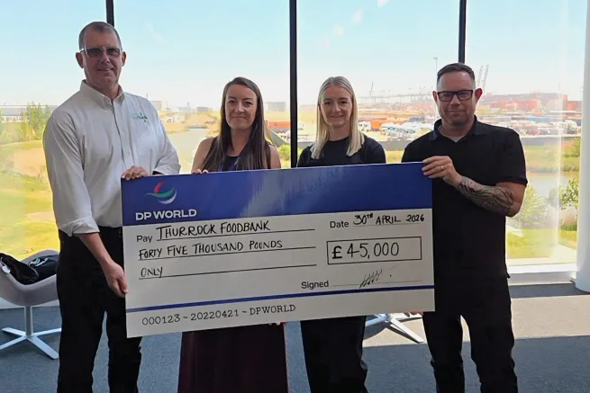 Dp world staff present cheque to food bank staff