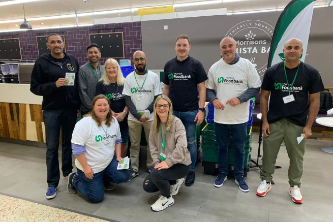 Nine volunteers in food bank tshirts in Morissons