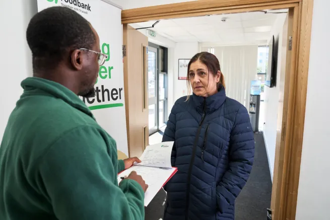Woman at food bank speaking to food bank volunteer
