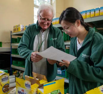 A man and a woman at Lewisham food bank looking at a piece of paper