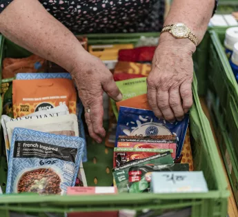 Hands packing a green tray with food items