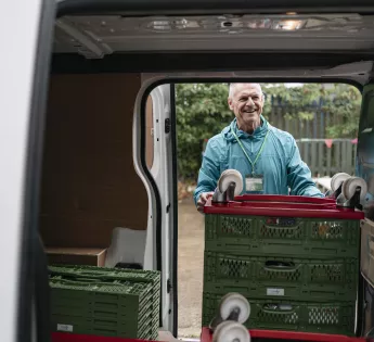 Foodbank volunteer loading food parcels into a van.