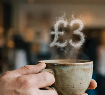 coffee cup with £3 above it
