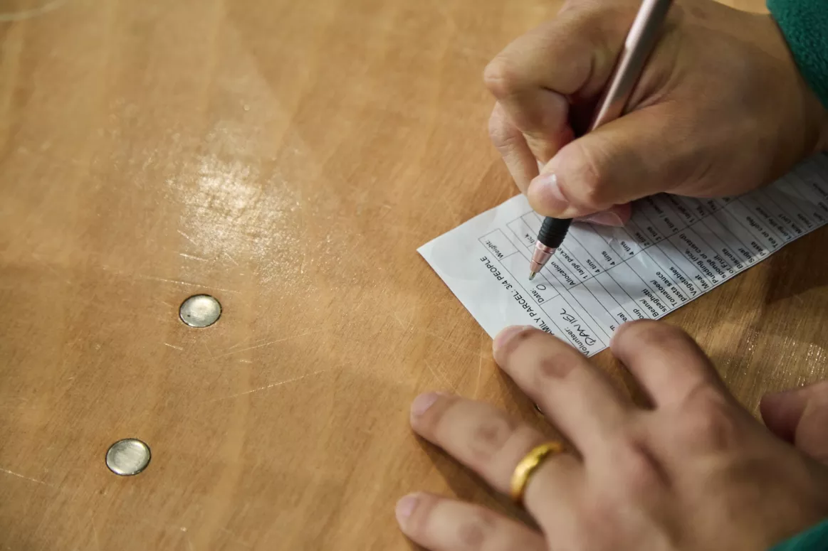 A person signing some paper at the Bradfood foodbank