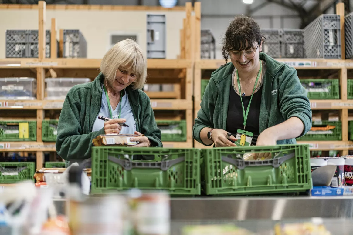 Foodbank volunteers organising food into crates.