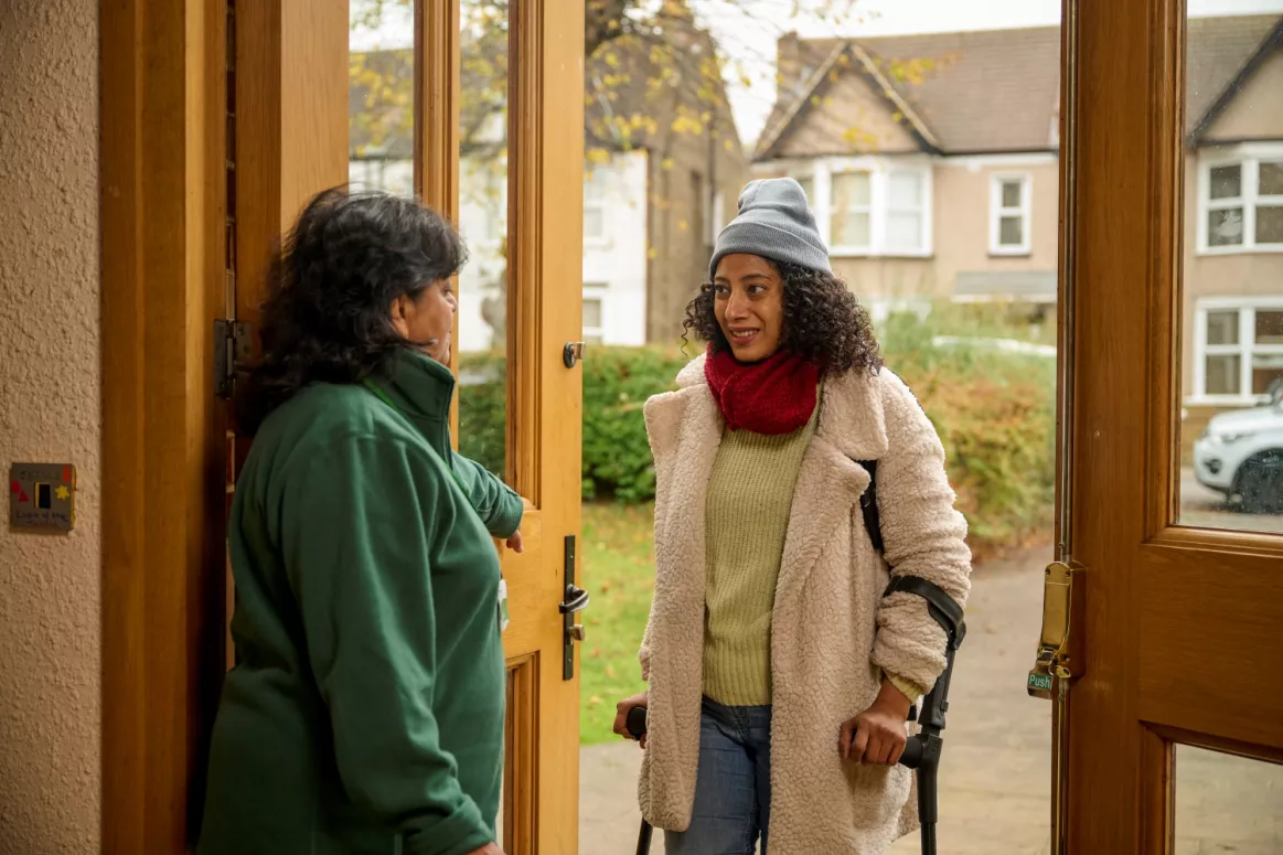 A food bank volunteer welcomes a visitor