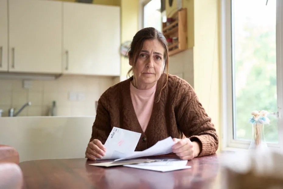 Woman sat at table, going through her bills