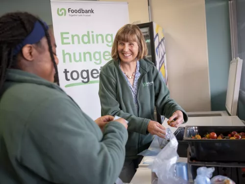 Two women packing tomatoes in to plastic bags at the Lisburn food bank