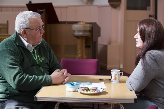 Two people talking at a desk