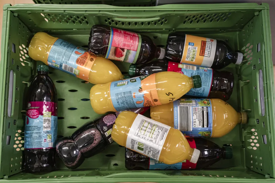 A crate full of squash bottles.