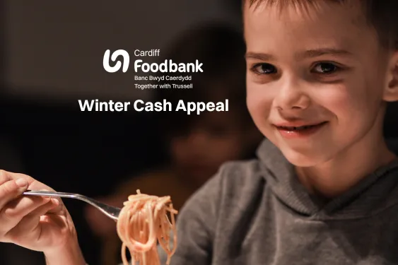 Boy holding fork with pasta. Image has words Cardiff Foodbank Winter Cash Appeal