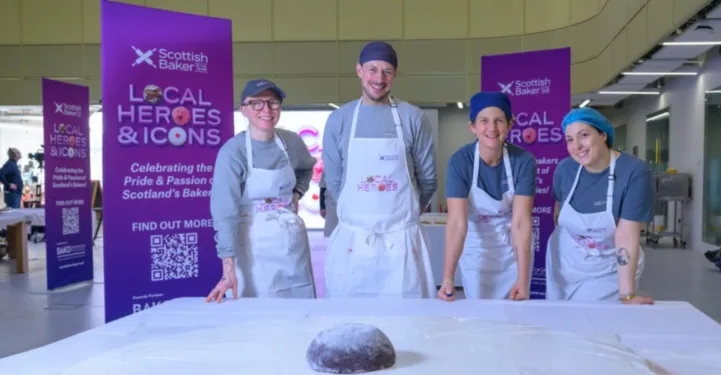 bakers standing next to a large empire biscuit
