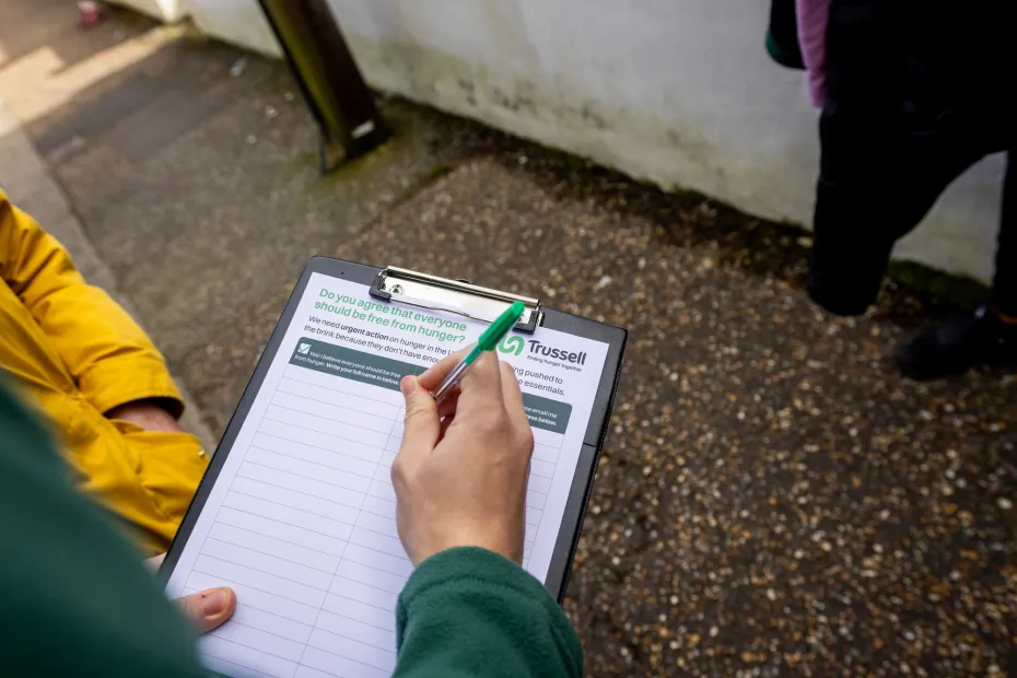 Hands of volunteer holding a clipboard with petition on it