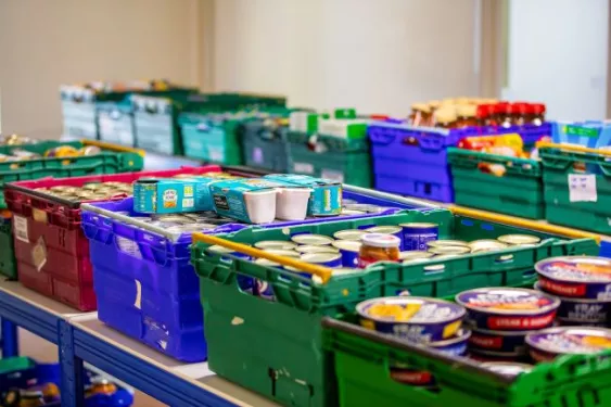 Crates of food items, including tins, at a food bank warehouse
