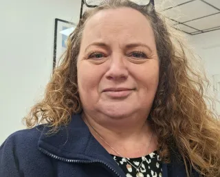 Blond middle aged lady with glasses on her head