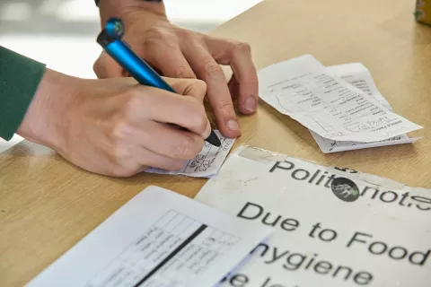 A person signing some paper at the Bradfood foodbank