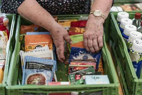 Hands packing a green tray with food items