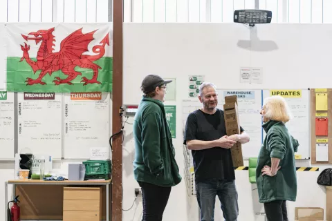 A group of food bank volunteers and staff chatting.