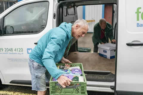 Foodbank volunteers loading crates of food into a van.