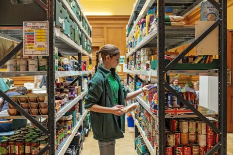 Food bank volunteer stacking shelves.