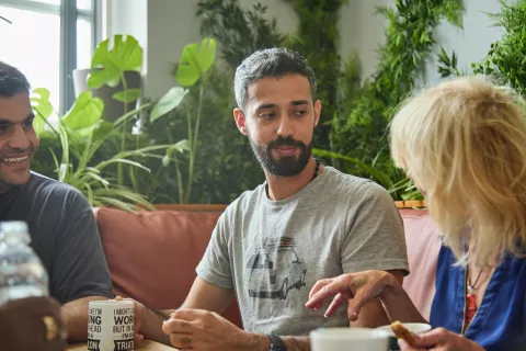 Three people have a conversation