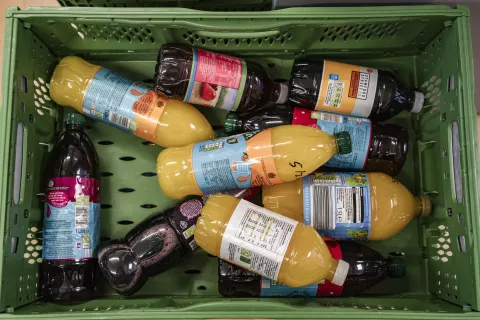 A crate full of squash bottles.