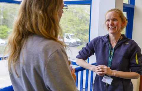 Smiling woman talking to a colleague