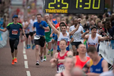 Runners crossing finish line at Manchester running event