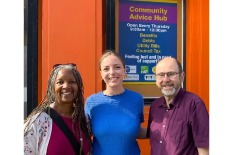 Three campaigners outside the Community advice hub